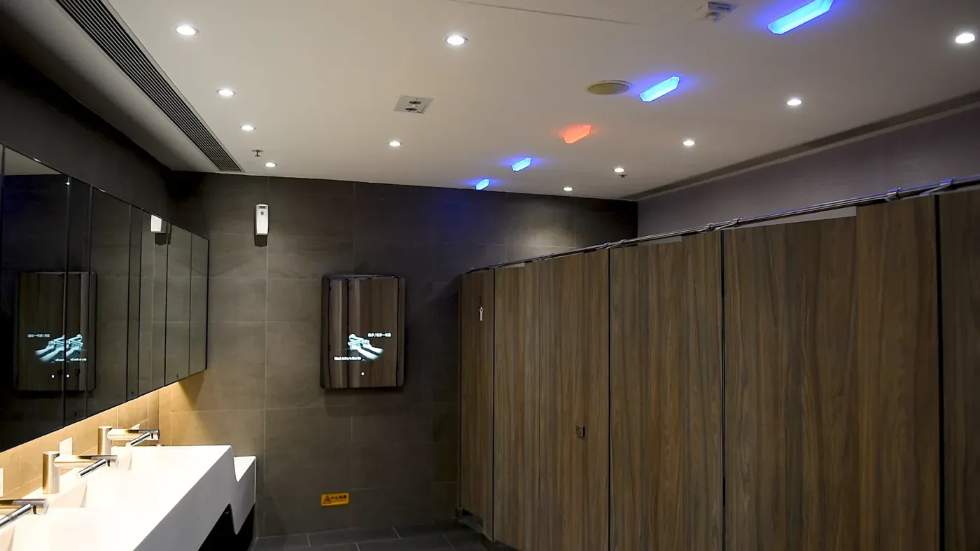 Washroom with coloured vacancy lights above the cubicle doors
